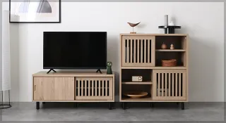 Wooden TV cabinet and matching shelving unit styled in a living room