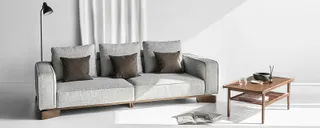 Gray three-seat sofa and wooden coffee table in a bright room