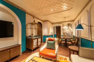 Furnished interior with teal walls, custom cabinetry, lounge seating and decorative lighting