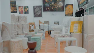 Showroom displaying woven tables, stools, baskets and framed artwork