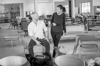 Two people standing among furniture in a bright showroom