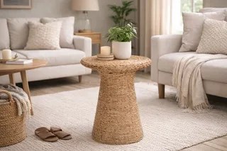 Round woven console table styled between two sofas