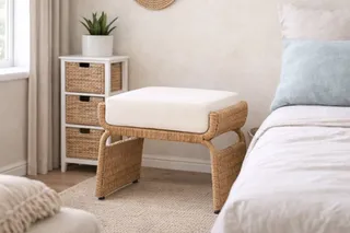Woven upholstered stool beside a bed
