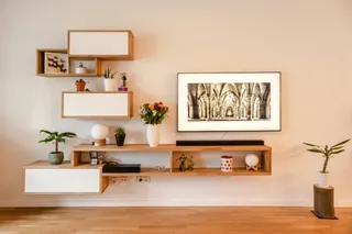 Woven wall shelving and console furniture arranged in a bright living room