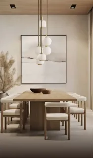 Light wood dining table with upholstered chairs beneath pendant lights.