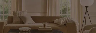 Neutral upholstered sofa with cushions, coffee table and floor lamp in a bright living room.