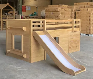 Wooden children's bunk bed with slide photographed inside a factory