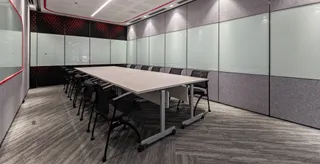 Conference room with a large meeting table, chairs and acoustic wall panels