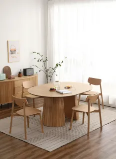 Round wooden dining table and chairs in a furnished dining room