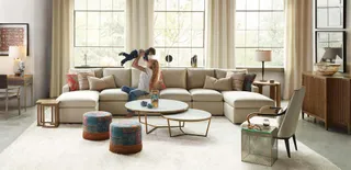 Furnished living room with a sectional sofa, coffee tables, armchairs and wooden cabinetry
