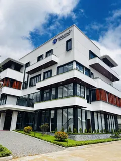 Modern multi-storey company building with landscaped grounds and visible signage.