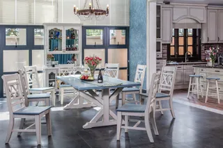 Showroom dining area with painted table, chairs and display cabinet