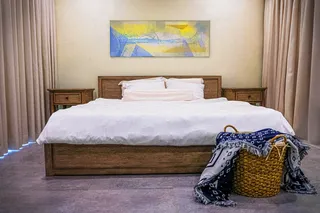 Finished wooden bed with matching bedside tables in a bedroom
