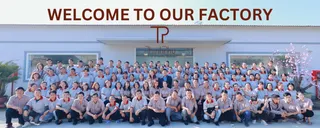 Large staff group standing outside a furniture factory