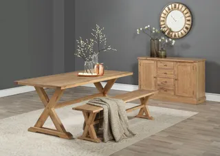 Wooden dining table, benches and sideboard in a staged room