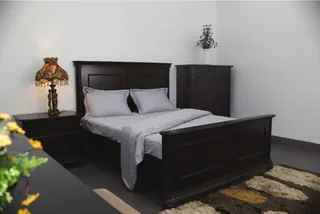 Dark wooden bedroom set with bed, dressers and bedside tables