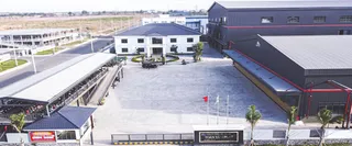 Aerial view of a large factory campus with buildings, yard and loading areas