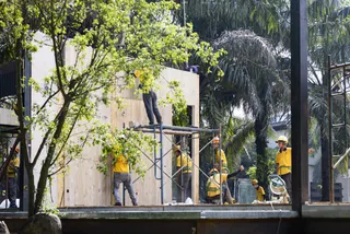 Workers in yellow safety clothing installing a timber wall and structure outdoors