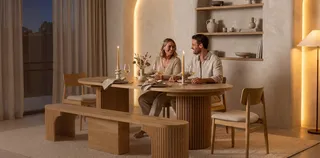 Wooden dining table, bench, and chairs arranged in a finished dining room