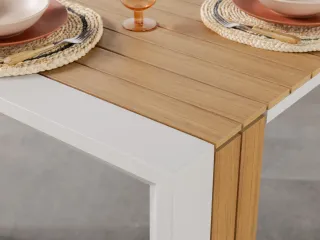 Close-up of a wooden dining table with slatted top and white supporting frame