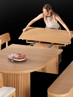 Person expanding a rounded wooden dining table