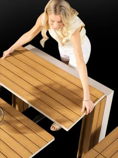 Person extending a slatted wooden dining table