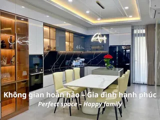 Modern fitted kitchen with black backsplash, island and dining table