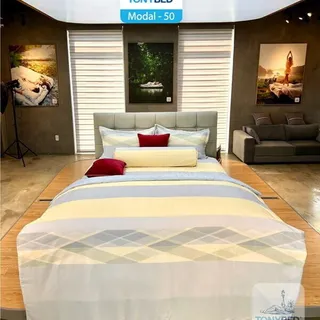 Showroom bed dressed in a multicolored striped Tonybed bedding set