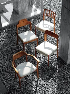 Four wooden chairs with white upholstered seats on a gravel floor