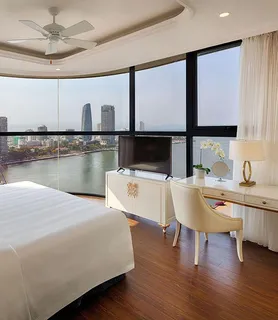 Finished bedroom with white furniture and a river view