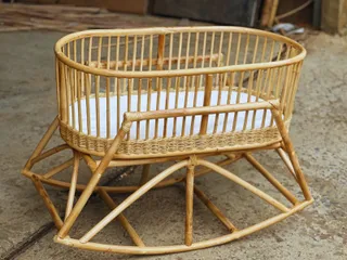 Woven rattan baby bassinet with raised frame