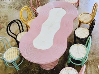 Colorful woven rattan table surrounded by matching chairs