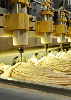 CNC carving machine cutting decorative wooden furniture parts.