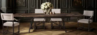 Dark wood dining table with upholstered chairs in an elegant interior.