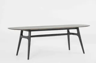 Long oval dining table with a dark frame and tapered legs.