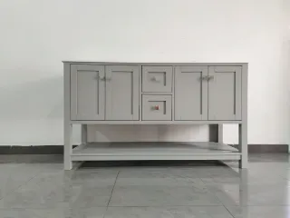 Light gray sideboard with paneled doors, drawers and an open lower shelf