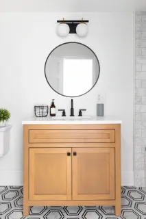 Light wood bathroom vanity with two doors, a drawer and white countertop