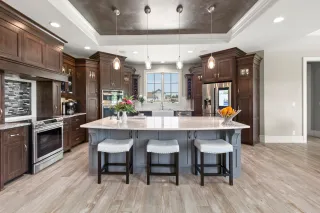 Dark wood kitchen cabinetry surrounding a central island with seating