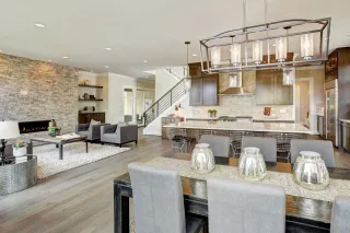 Open-plan kitchen with gray cabinets, island, dining table and living area