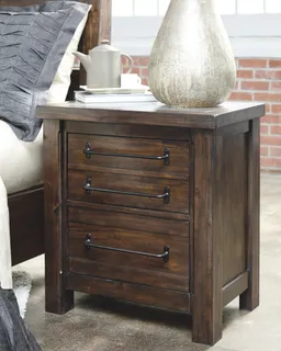 Dark wooden three-drawer bedside chest beside a bed