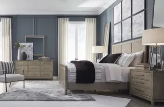 Contemporary bedroom furnished with a bed, dressers, bedside tables and chair